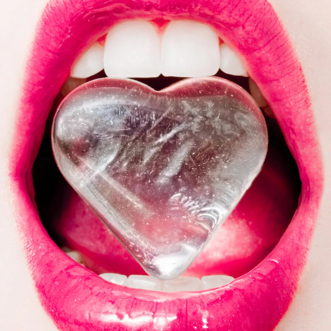 mouth holding heart shaped ice cube