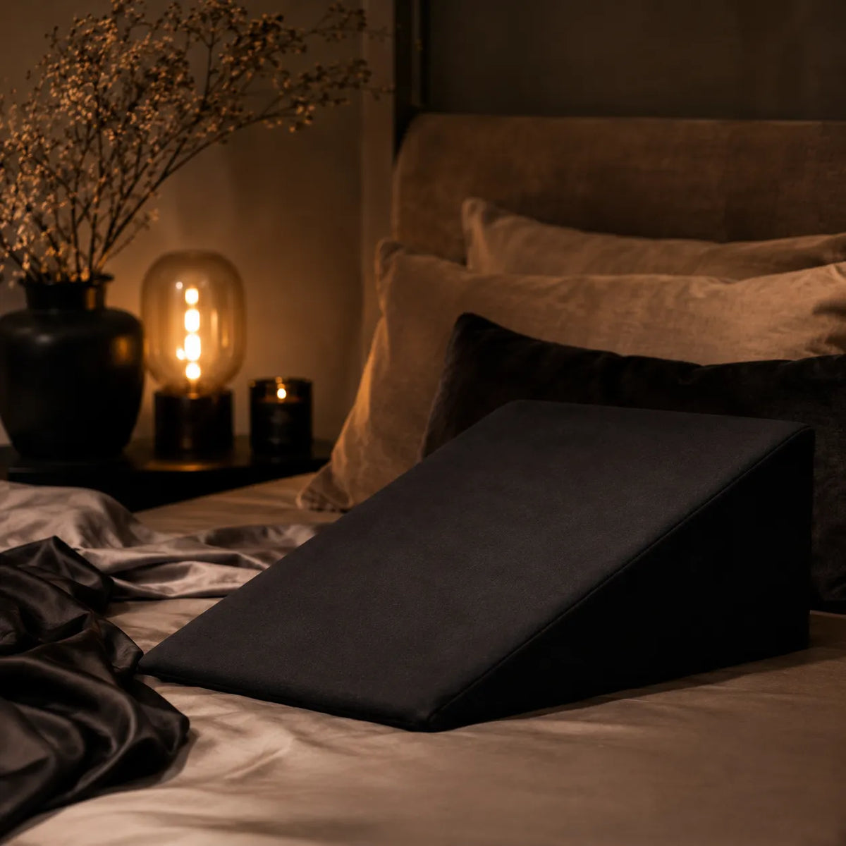 dim lighting in a bedroom with a black ramp on bed