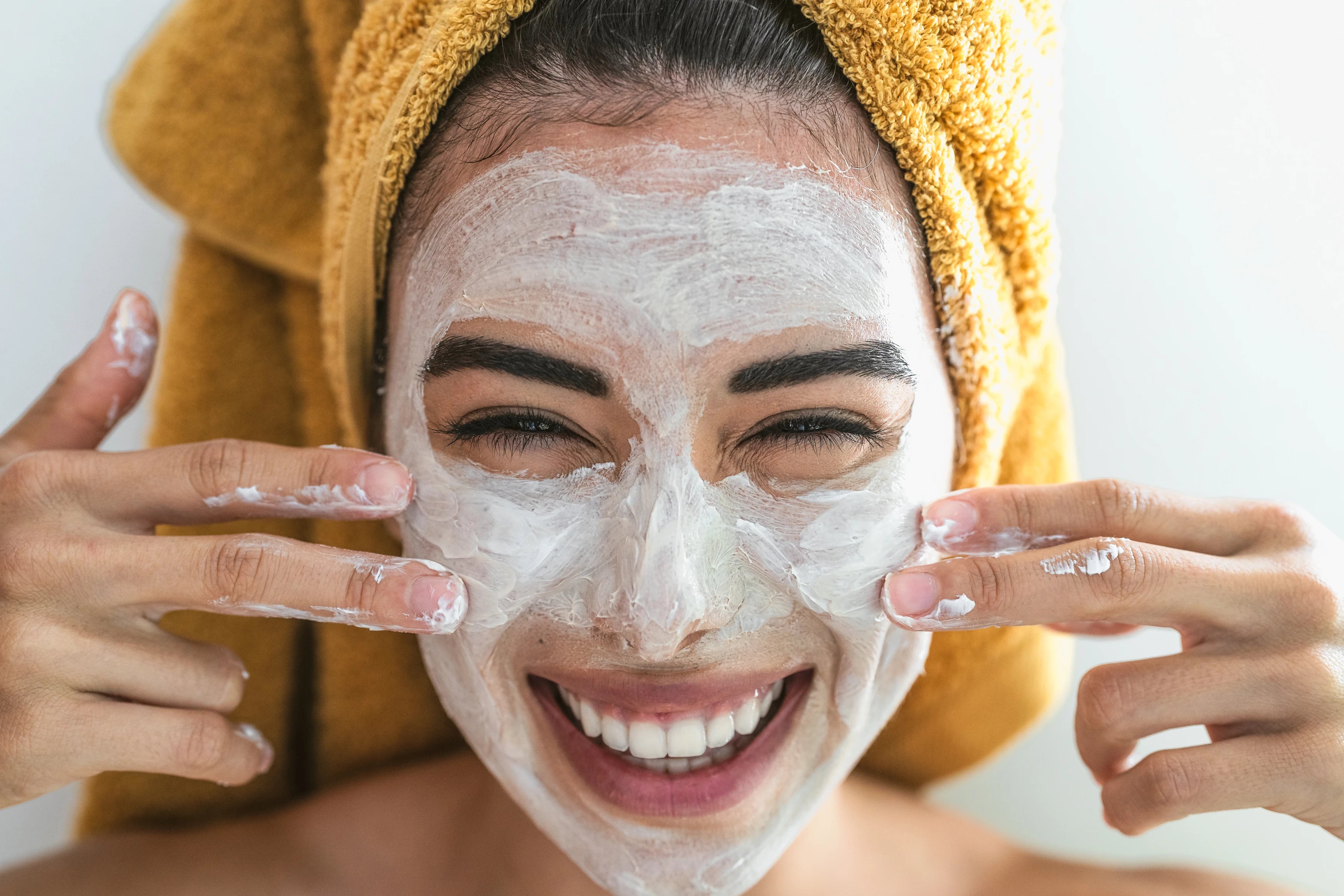 Person enjoying a facial mask, smiling at the camera.