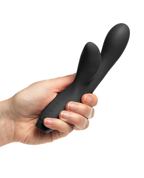 Hand holding a black electronic device on a white background