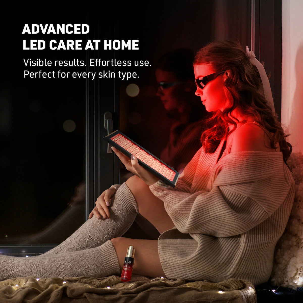 Woman sitting with red light panel facing her