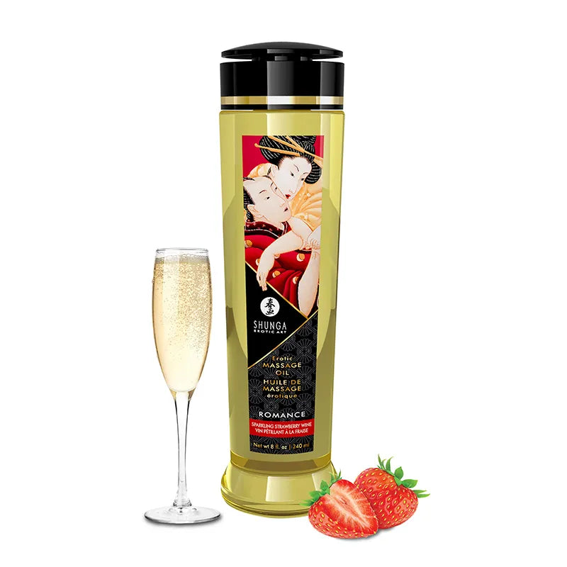 Bottle of Shunga massage oil with a glass of champagne and strawberries on a white background