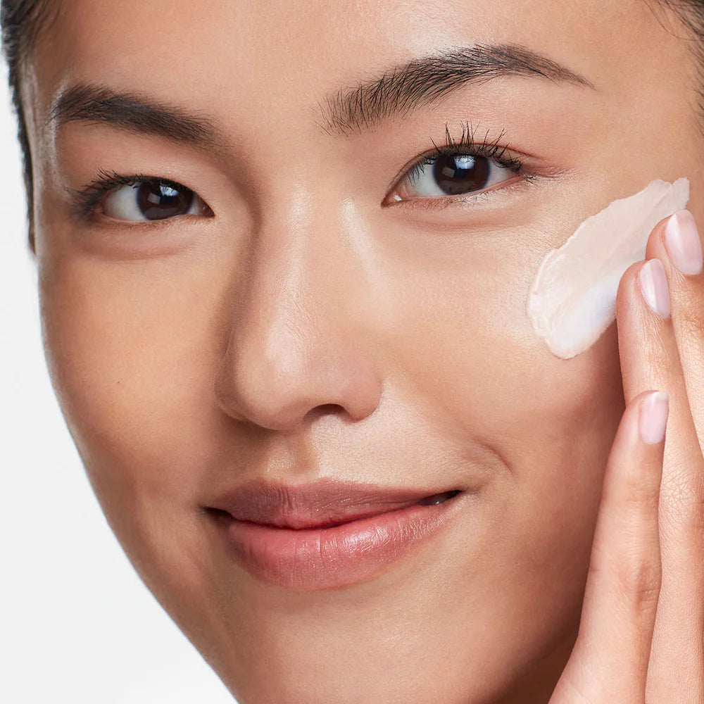 Woman applying cream to her face with a close-up view.