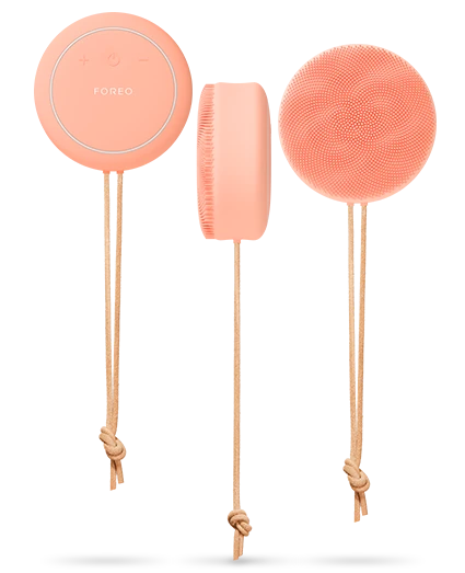 Set of three orange silicone sponges with handles on a white background