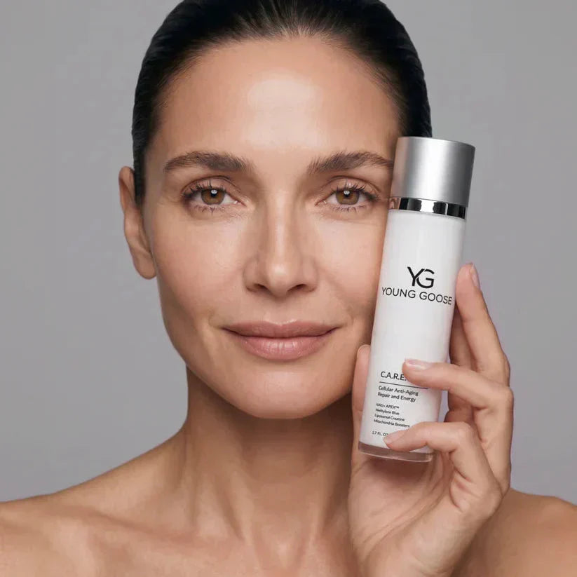 woman holding Young Goose moisturizer bottle up to her cheek