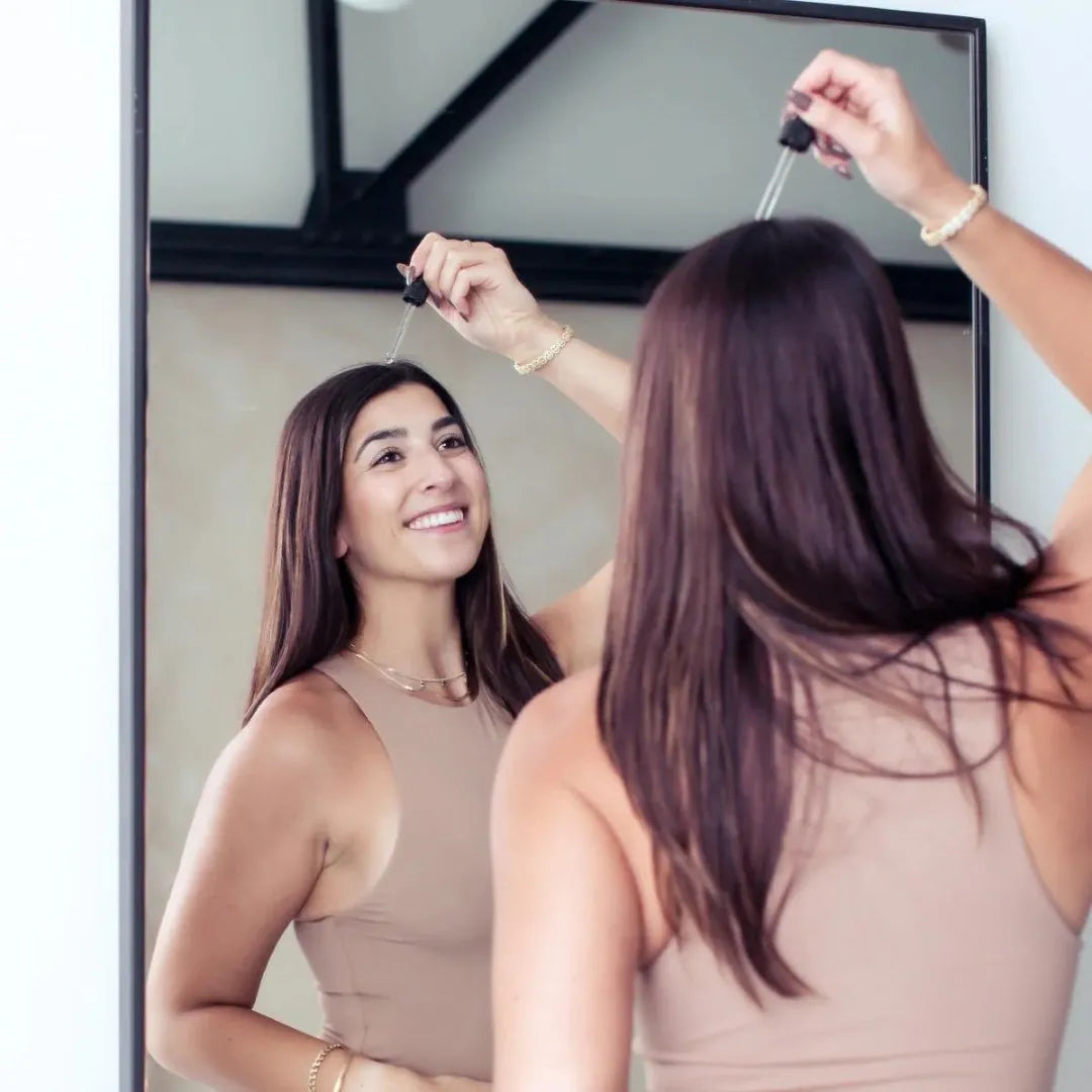 woman putting serum on her scalp
