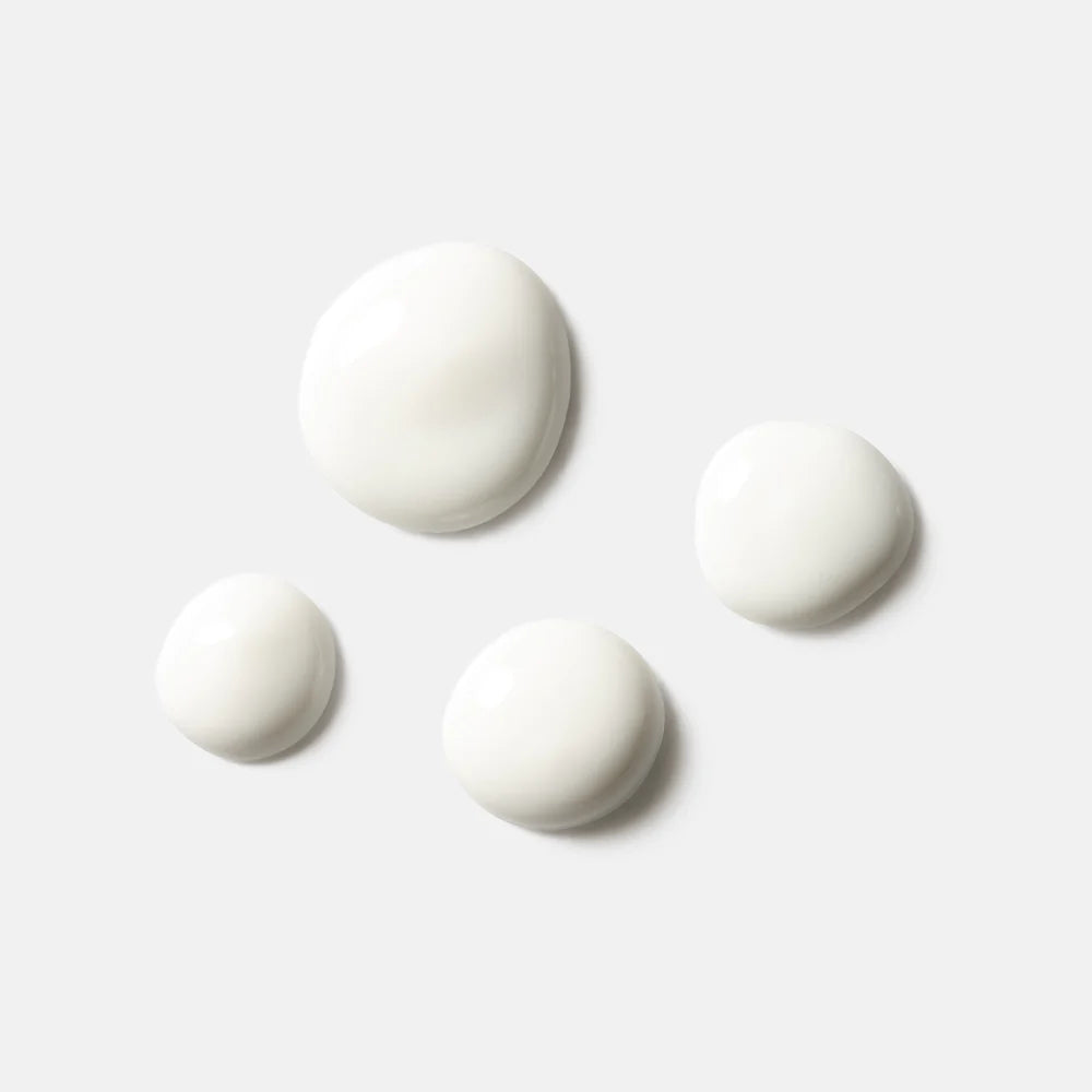 Four white cream dots on a light gray background