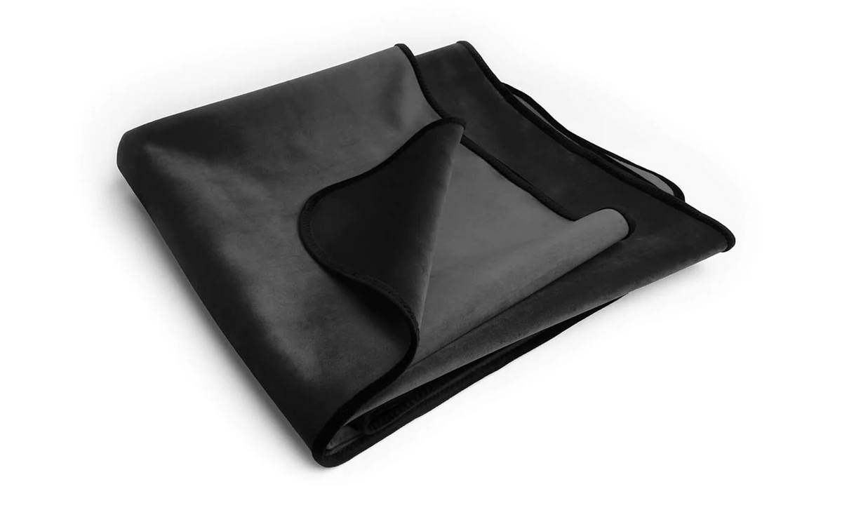 Black velvet blanket folded on a white background