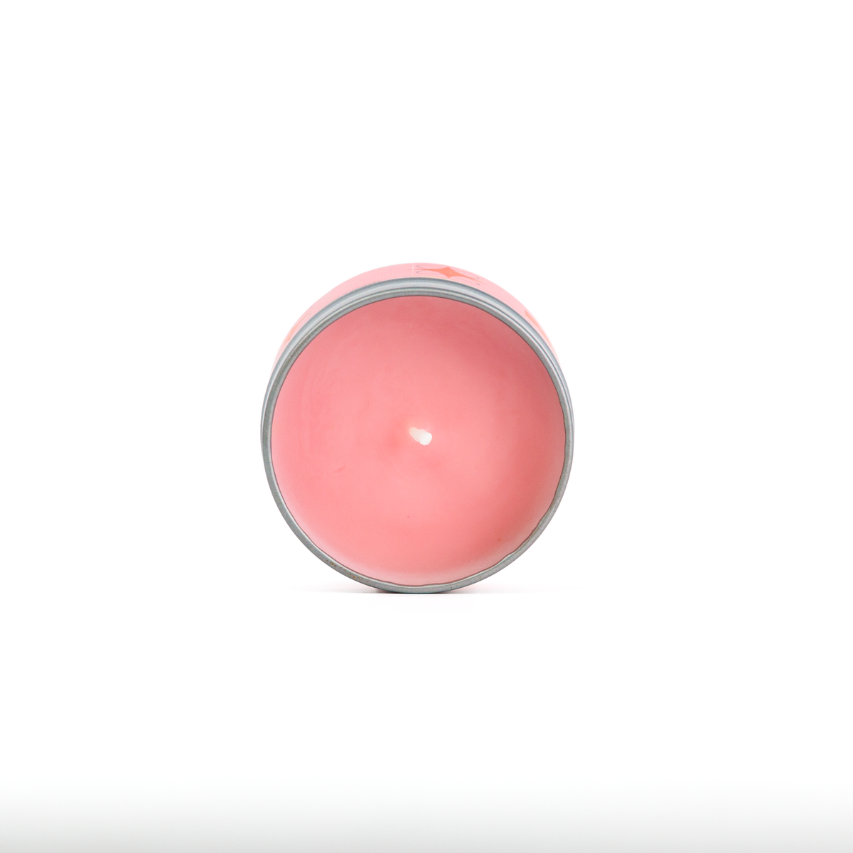 A round pink wax candle in a clear glass container, viewed from directly above on a white background.