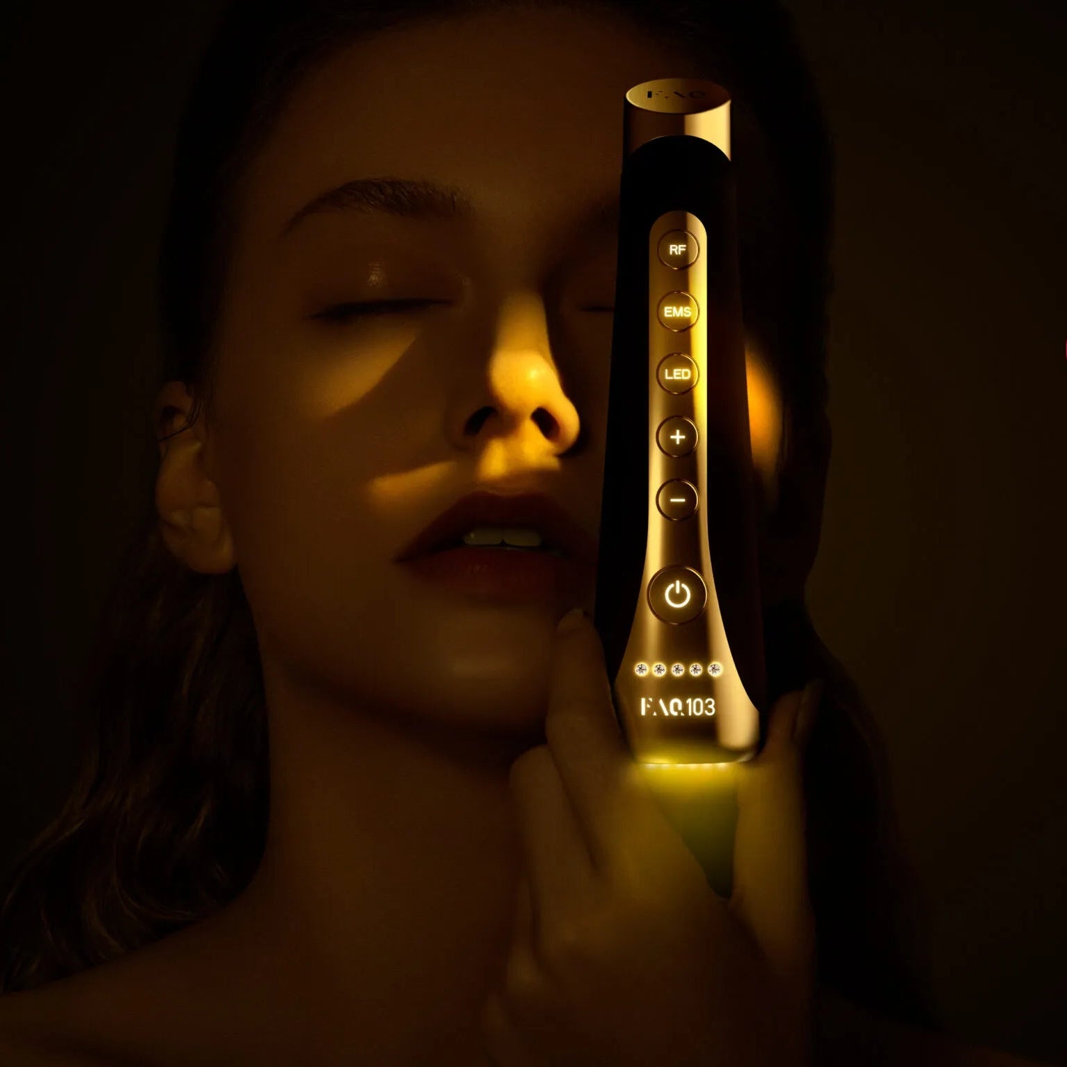A woman holds a gold and black facial beauty device against her cheek in a dimly lit setting. The image includes product text reading 'FAQ 103 Diamond' and 'REAL DIAMONDS GET BETTER WITH AGE,' plus small product pack shots and a Swiss Made logo.