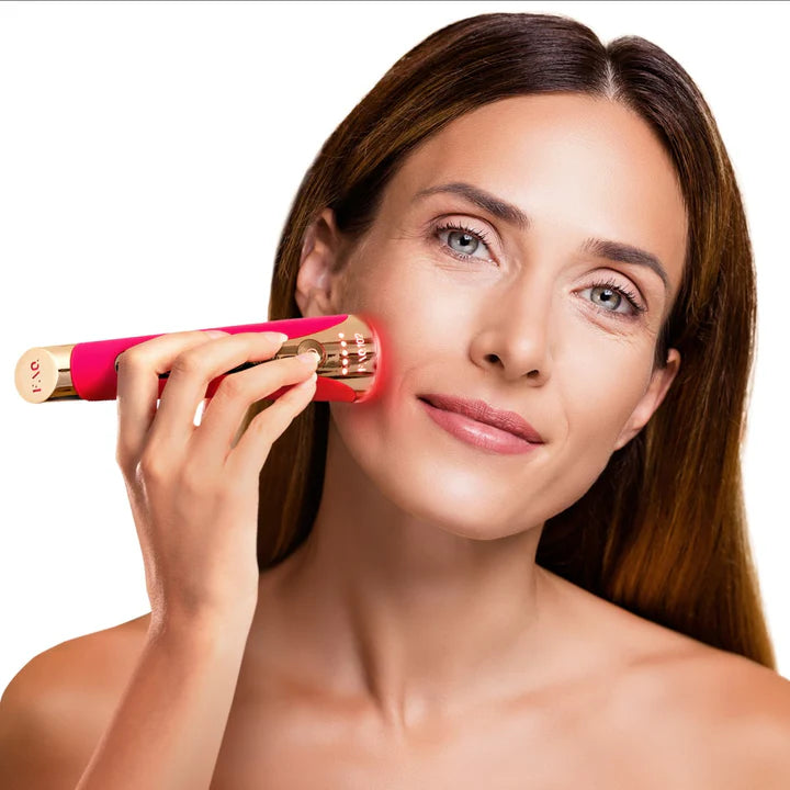 woman holding pink FAQ device to her cheek