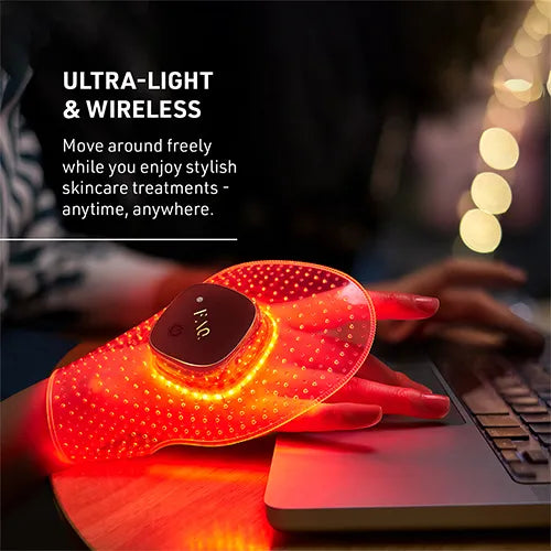 A red LED light therapy hand massager being used on a hand resting on a laptop keyboard, with promotional text on the left reading 'ULTRA-LIGHT & WIRELESS'.