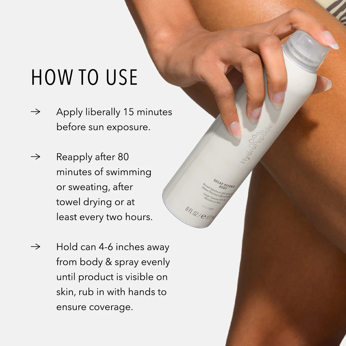 Person applying sunscreen spray with usage instructions on a white background