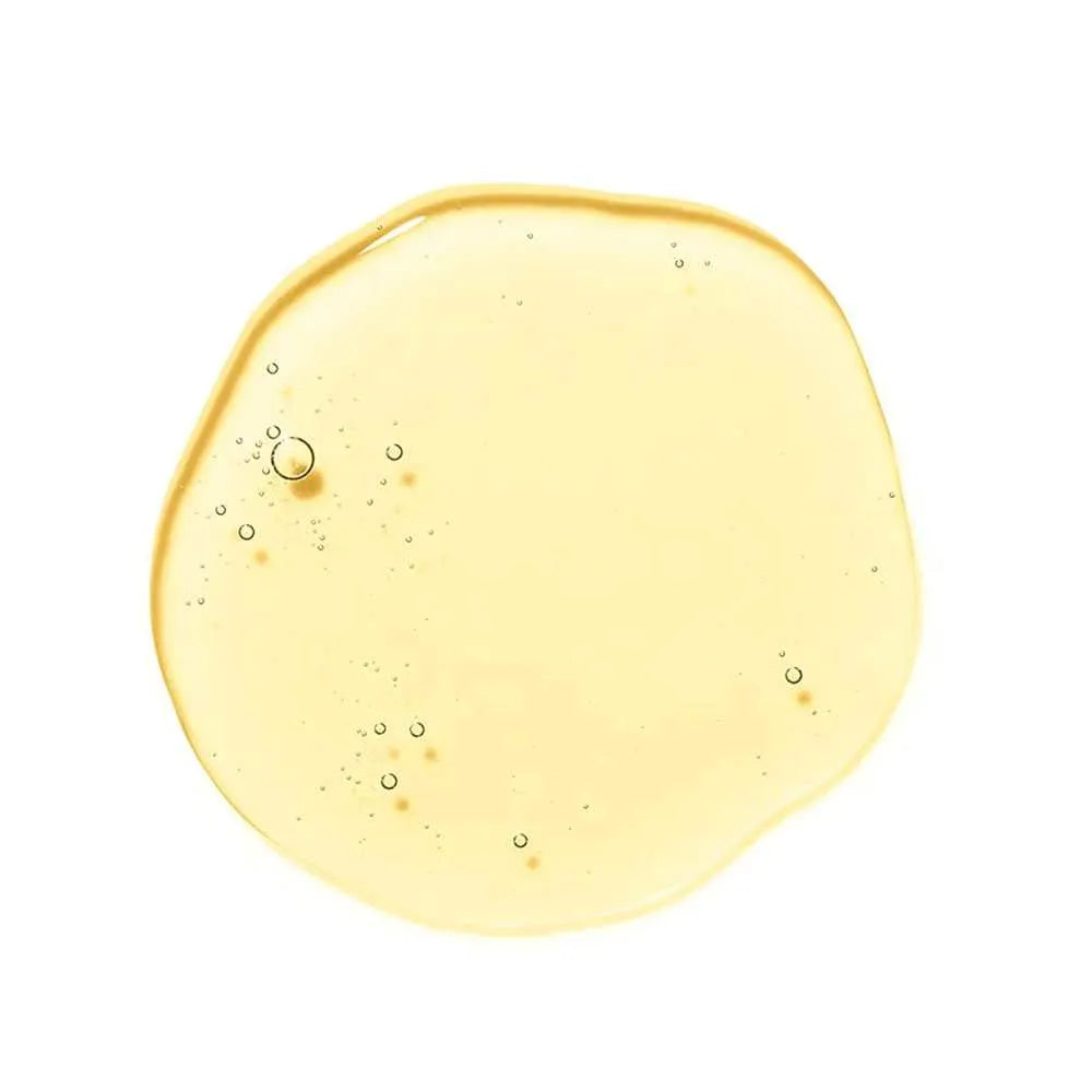Yellow liquid droplet with bubbles on a white background