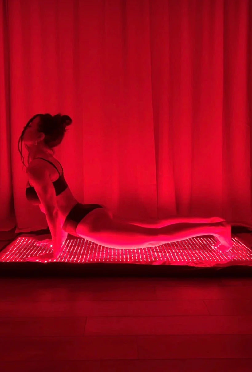 woman doing yoga on red light mat