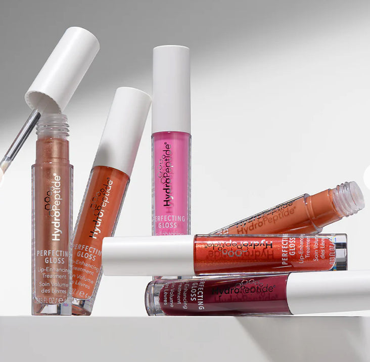 Collection of Hydropeptide lip glosses on a light gray background