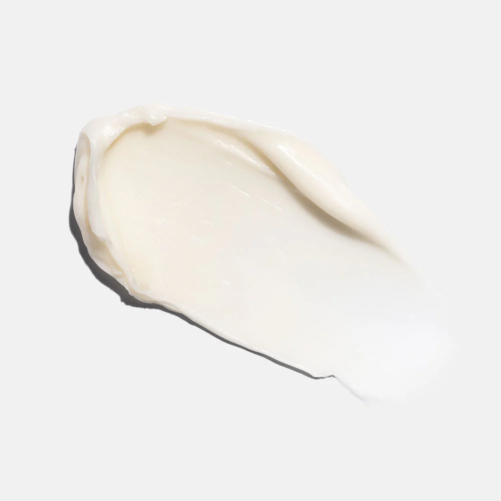 Close-up of a smear of white cream on a light gray background