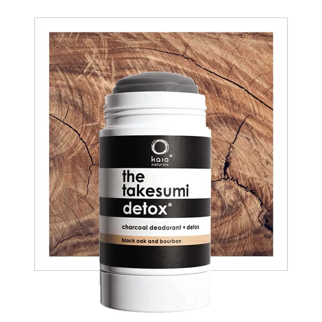 Deodorant stick with 'the takesumi detox' label on a wooden background