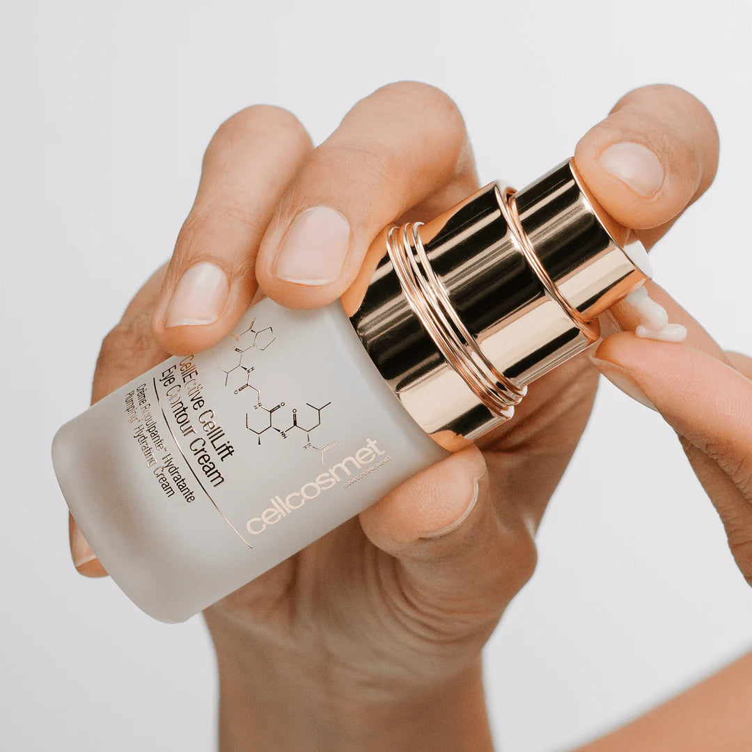 Hand holding a skincare product with 'cellcosmet' branding against a neutral background