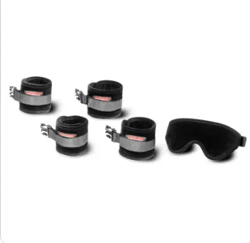 Four black wrist restraints with silver metal clamps and a black eye mask, arranged on a plain white background.