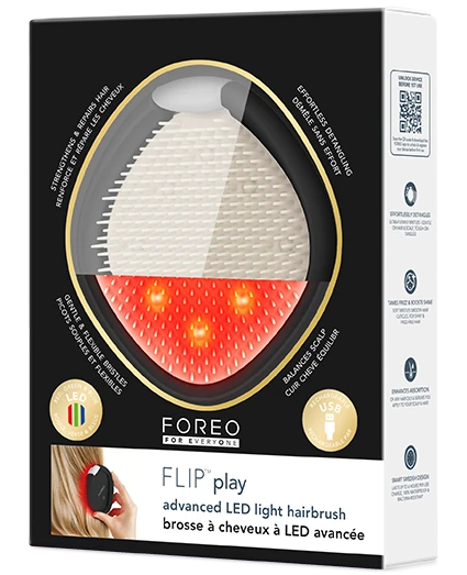 FOREO FLIP play hairbrush in its retail packaging, featuring a black box with a clear window showing the white bristle head and red LED light area.