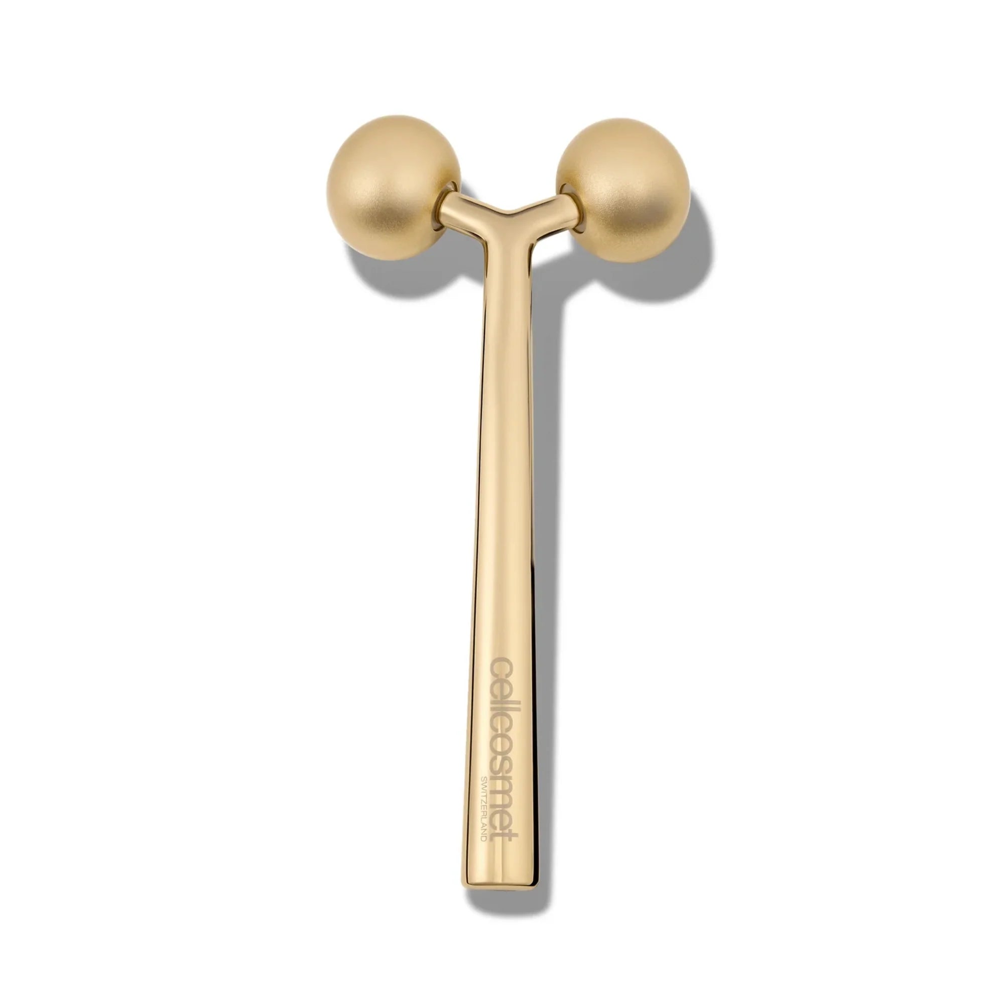 Gold facial roller with Cellcosmet name on a white background