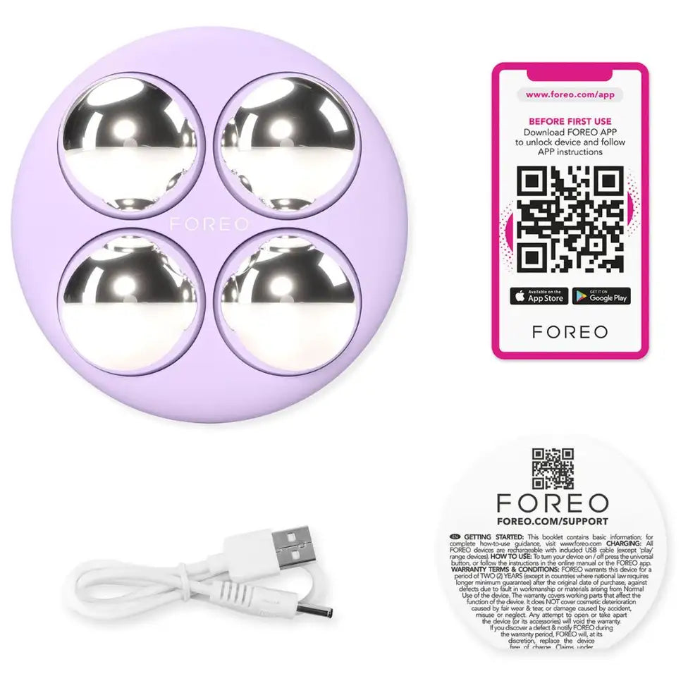 Purple device with metallic spheres, USB cable, and FOREO branded materials on a white background