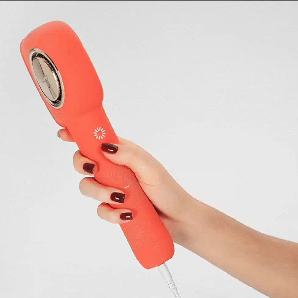 Hand holding a red handheld device with a white background
