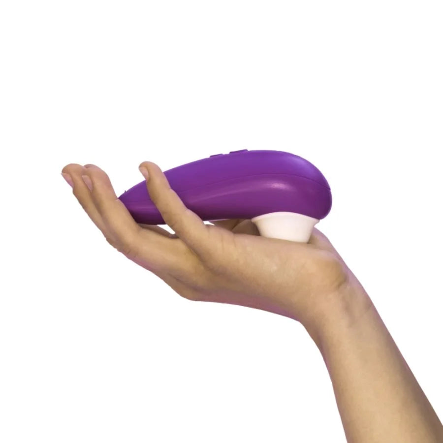 Purple and white device held in a hand on a white background