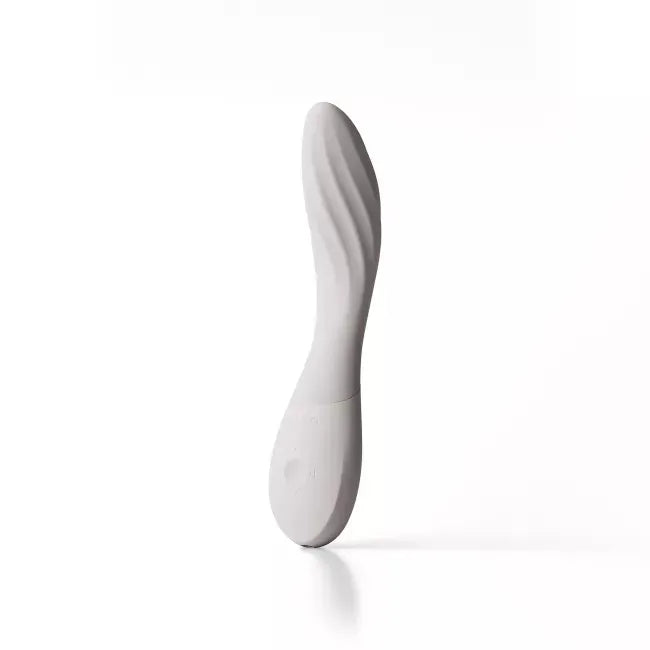 A white silicone personal massager with a curved, ribbed shaft and a smooth base, standing upright on a clean white background with a soft reflection.