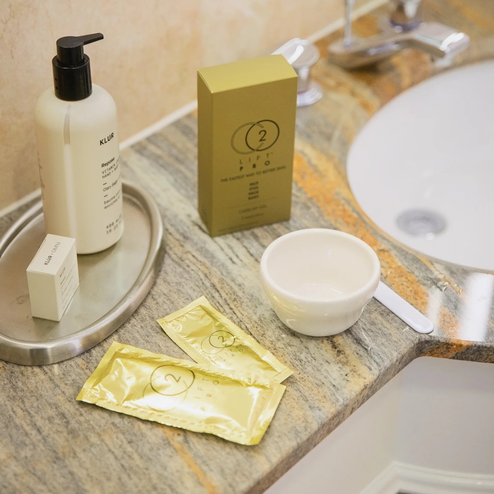 Bathroom counter with CO2 Lift Pro Carboxy Therapy Topical Gel Mask products and a bottle, box, and packets.