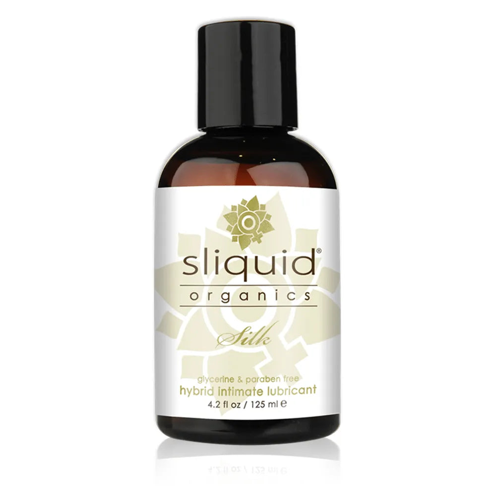 A bottle of Sliquid Organics Silk hybrid intimate lubricant, featuring a dark amber glass bottle with a black cap and a white label with gold accents.