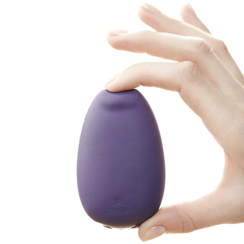 Hand holding a purple egg-shaped device with a brand logo on a white background
