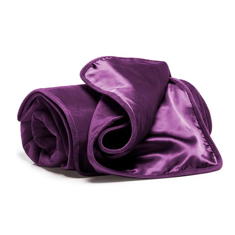 Rolled-up purple velvet blanket on a white background
