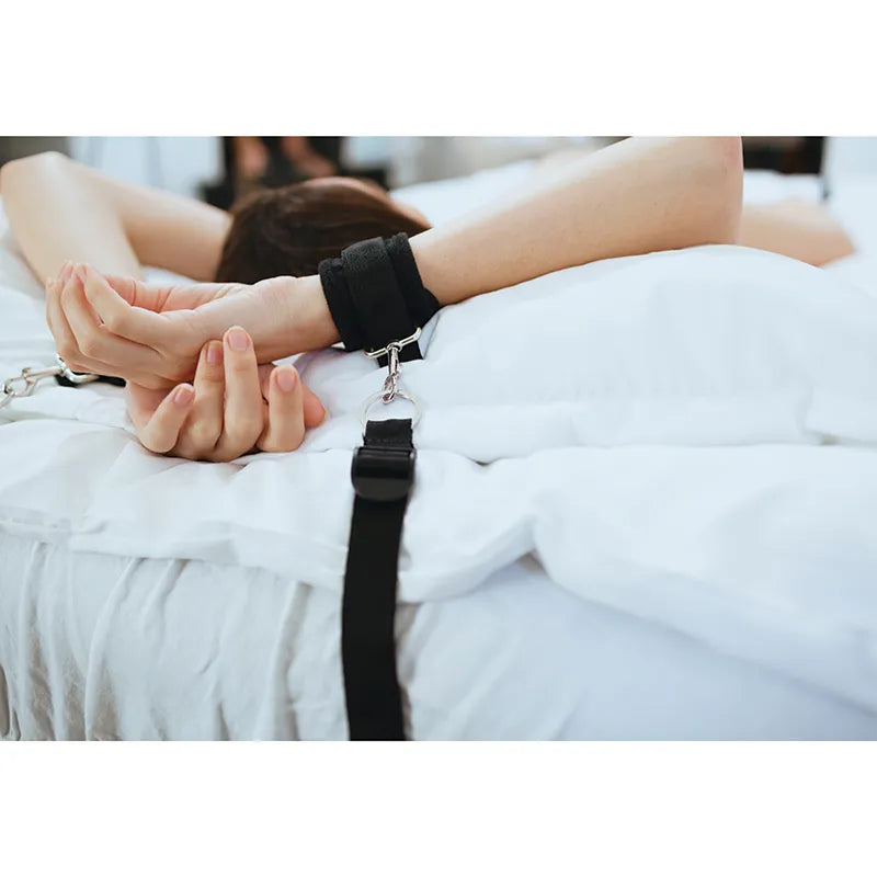 Person with hands cuffed behind their back on a bed