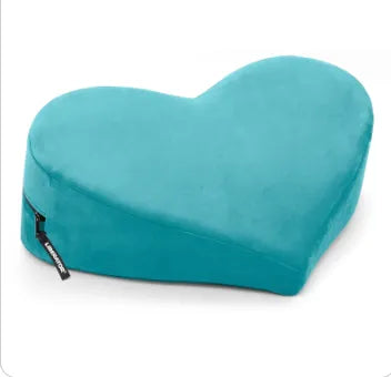 A heart-shaped contoured lumbar support pillow in a vibrant teal color, featuring a black zipper on the side with a small white brand tag.