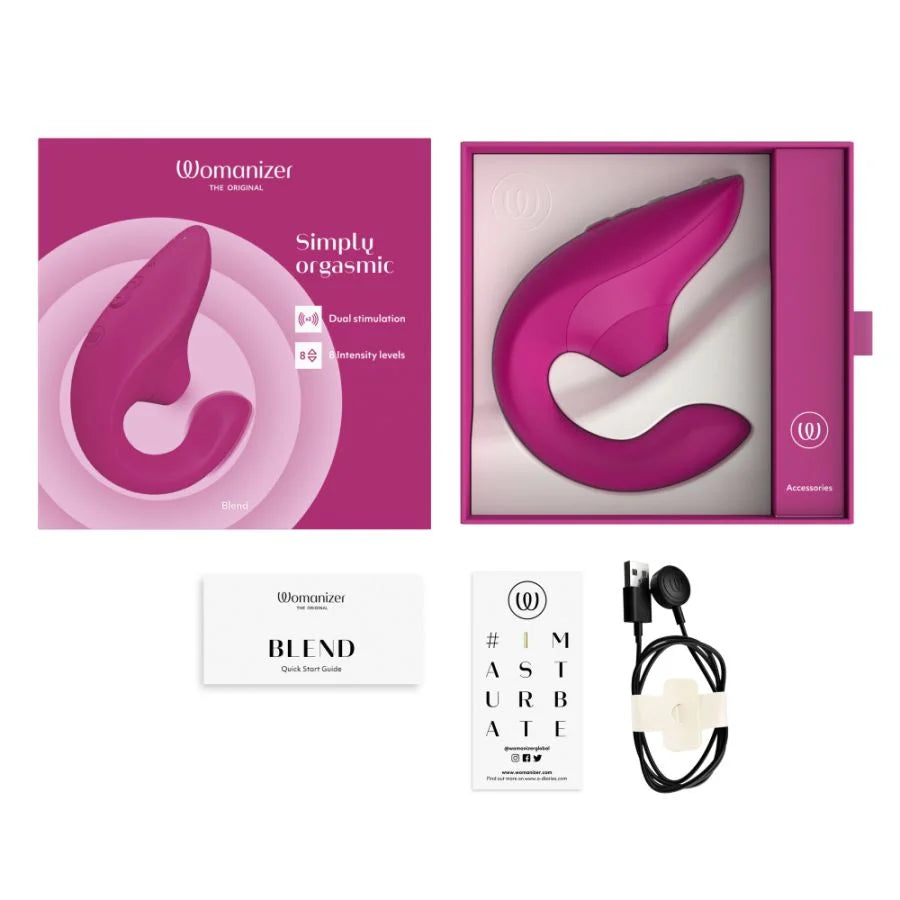 Womanizer Simply Orgasmic dual-stimulation massager set with its retail packaging, included in a white background layout. The set includes the magenta-pink curved wand massager inside and outside its box, a white quick-start guide card titled 'BLIND', an eye chart card, and a black wired remote control.