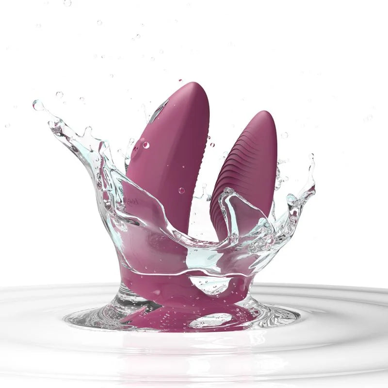 Purple massager with water splashes on a white background